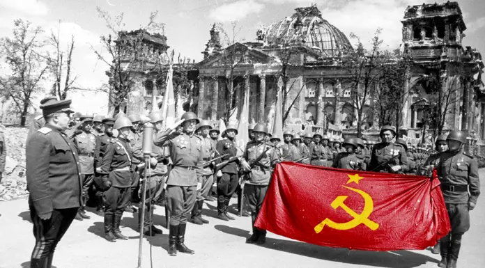 Правовая ничтожность государственной символики: флаг РФ, которого нет Флаг РФ незаконен. На фото: советские солдаты строем у Рейхстага разворачивают красное Знамя Победы — законный государственный символ СССР, в отличие от триколора, не имеющего юридической силы.